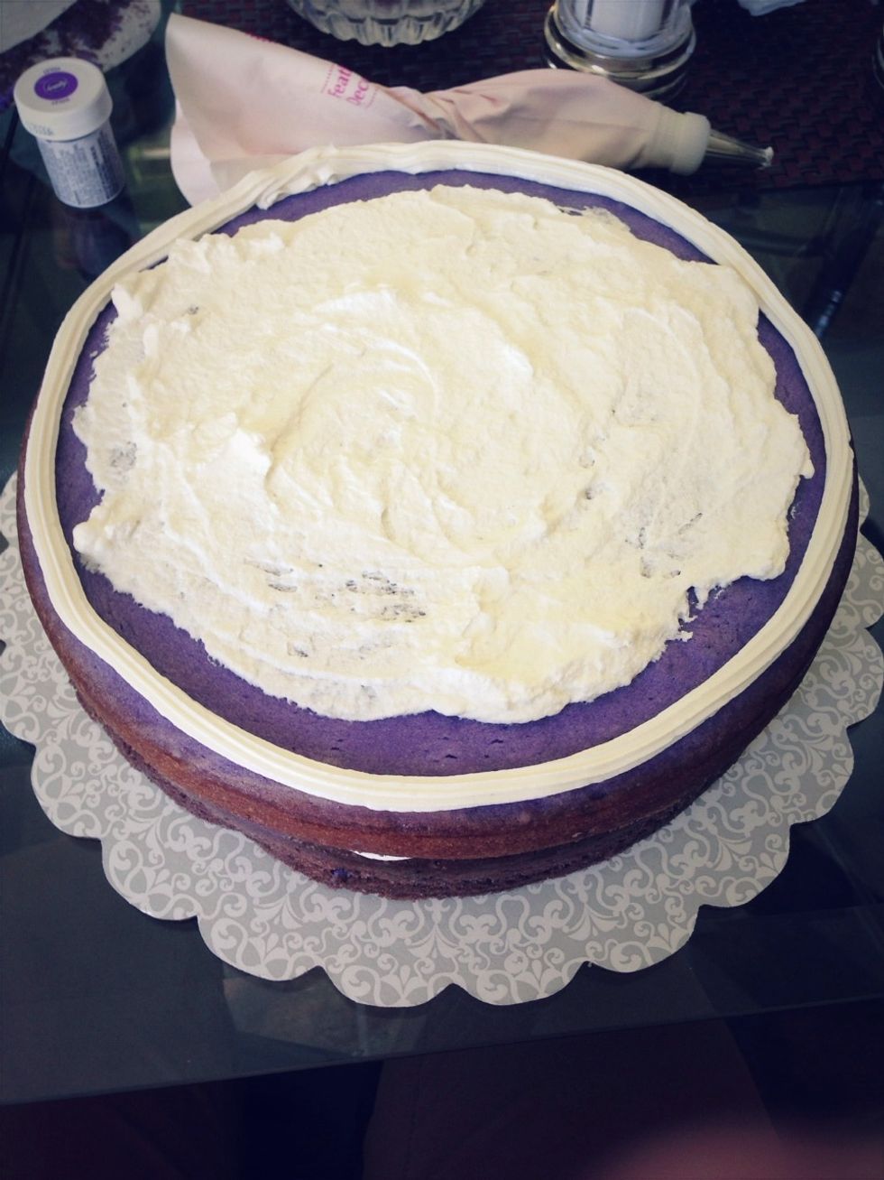 Before decorating, place your bottom(darkest) layer on a tray/mat as the final result will be heavy! Create a dam around the cake and spread some whipped cream as the filling between the layers.