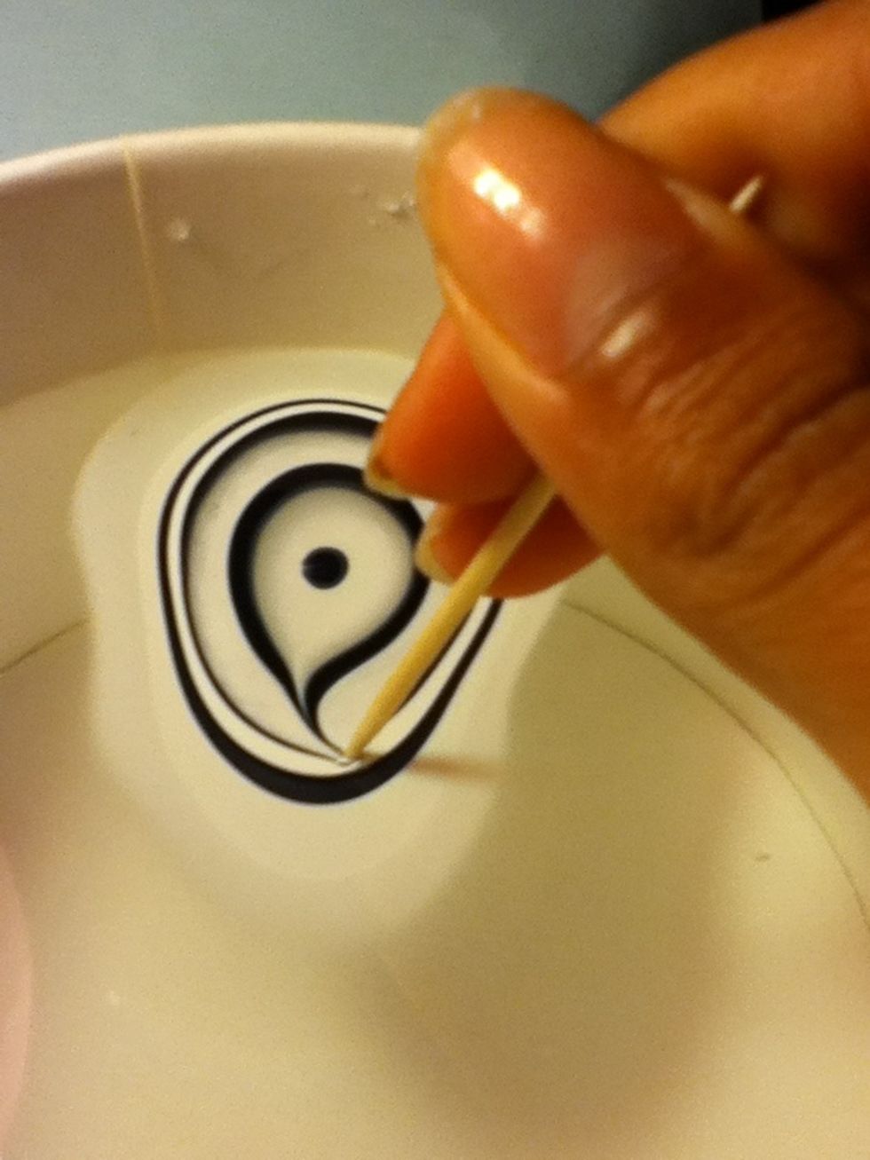 Before the nail polish drys, draw swirls in the nail polish