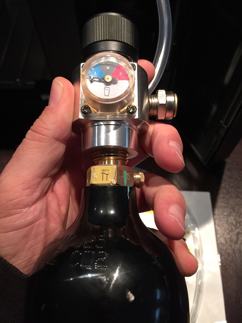 Before you can use it, the CO2 canister needs to be filled. Screw the canister into the regulator. Turn the valve to set the regulator so that the needle is in the middle.