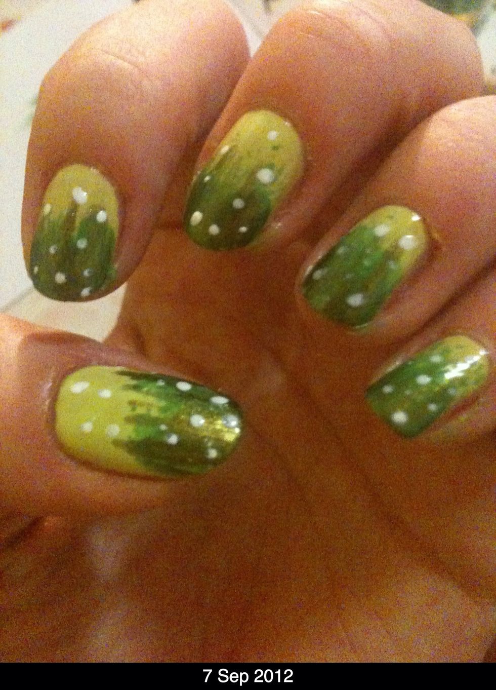 Before you dot white 'fairies' onto the nail, paint a sparkly/shimmery green over the bottom half-use a thin brush or striper to create a grass like effect. (Sorry If the photo isn't very clear)