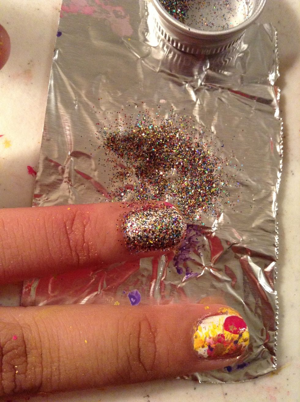 Before you remove the excess glitter , tap it gently so more can stick on the nail polish