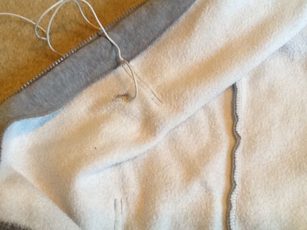 Begin by inserting the end that goes into your device into the pocket hole, and fish the other end, headphones and all up towards the hood