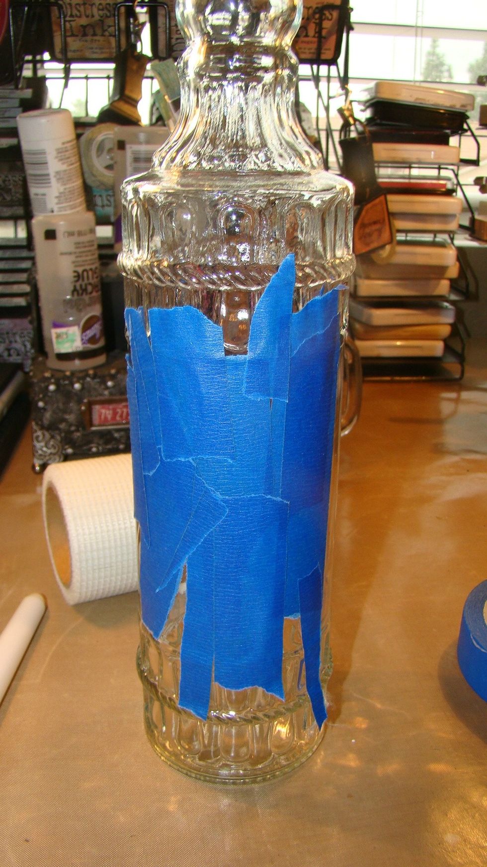 Begin by masking off a portion of the bottle so the inside contents can be seen once you've altered the bottle.