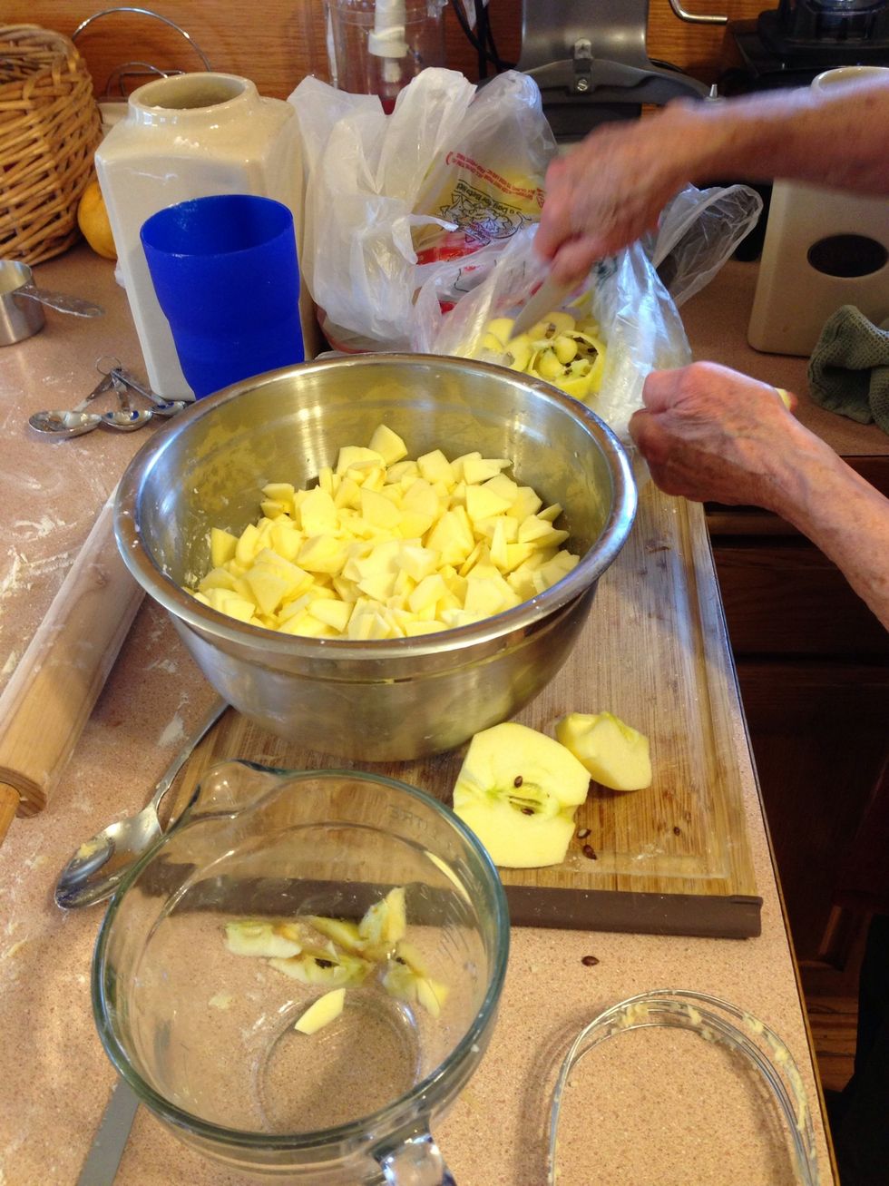 Begin coring and slicing the apples into pieces. Use the bowl that the dough was made in. The flour scraps in it are important.