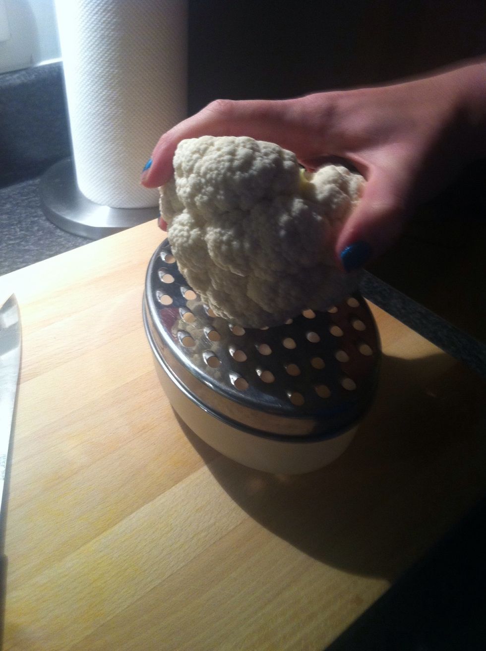 Begin grating florets and rotate frequently so that more of the cauliflower is used.