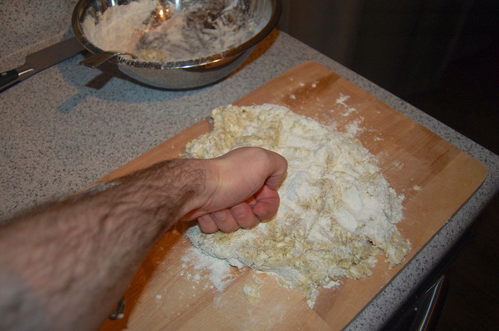 Begin kneading flour into dough until it holds together. I am using my fist but if it gets too sticky, use your palms.
