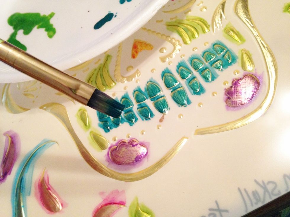 begin painting the raised design using your choice of Izink Ink colors and a small paint brush. to make painting easier, flip stencil over and lay on embossed side. then fill in the areas with color.