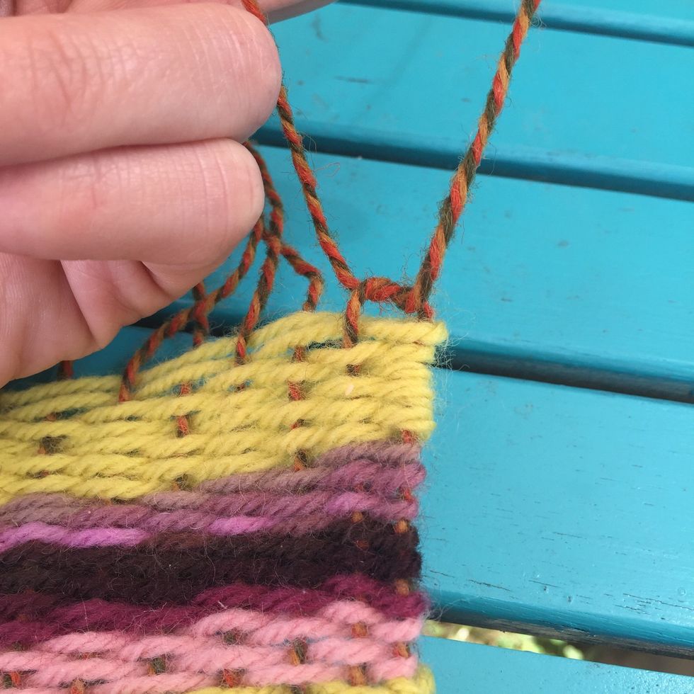 Begin pairing up the warp yarn with the piece next to it.  Tie them in a loose knot right above where the weaving begins.