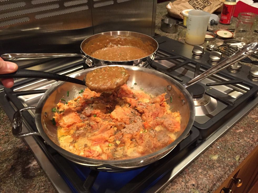 Begin to add the roux mixture incrementally to the crawfish/green onions and incorporate after each addition.