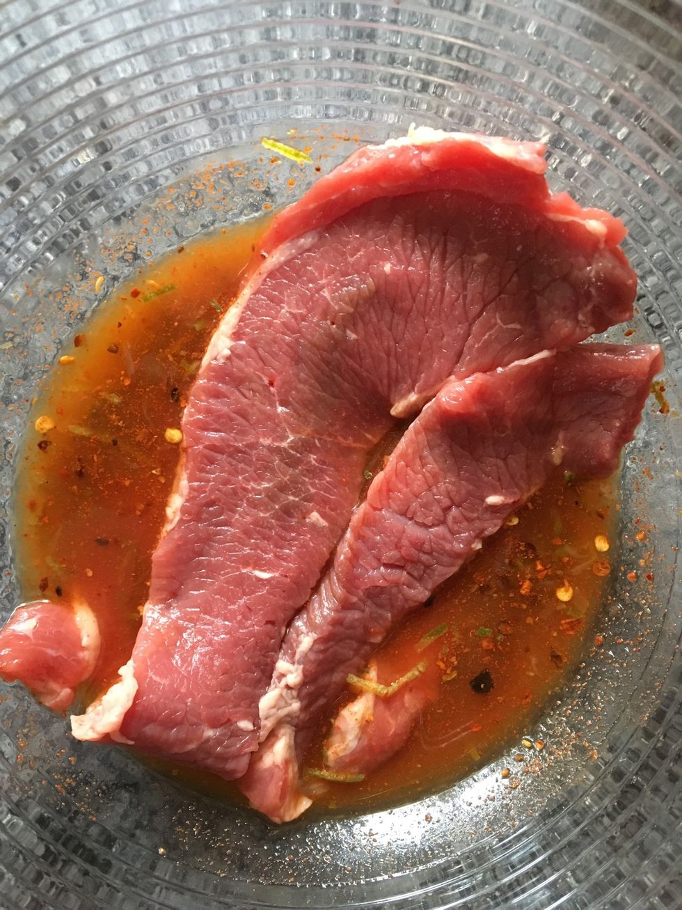 Begin to lay your brisket into your marinade