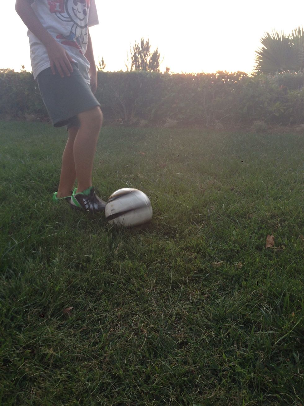 Begin to pick up the ball by bringing your foot back to you from the top of the ball to the bottom of the ball.