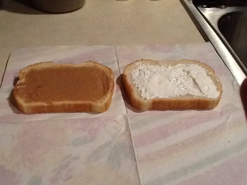 Begin to spread peanut butter on one slice of bread, and marshmallow cream on the other slice of bread.