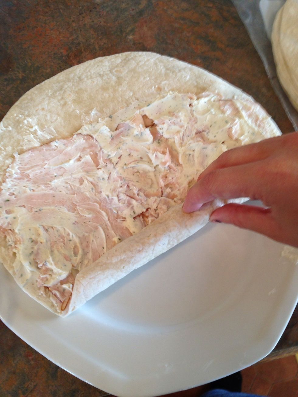Begin to TIGHTLY roll up the tortilla, with the blank 1/4 of the tortilla facing away from you.