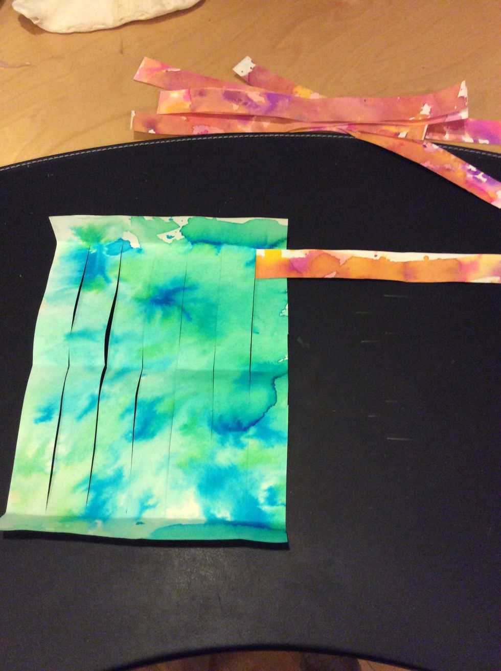 Begin to weave warm color strip over then under cool color strips.