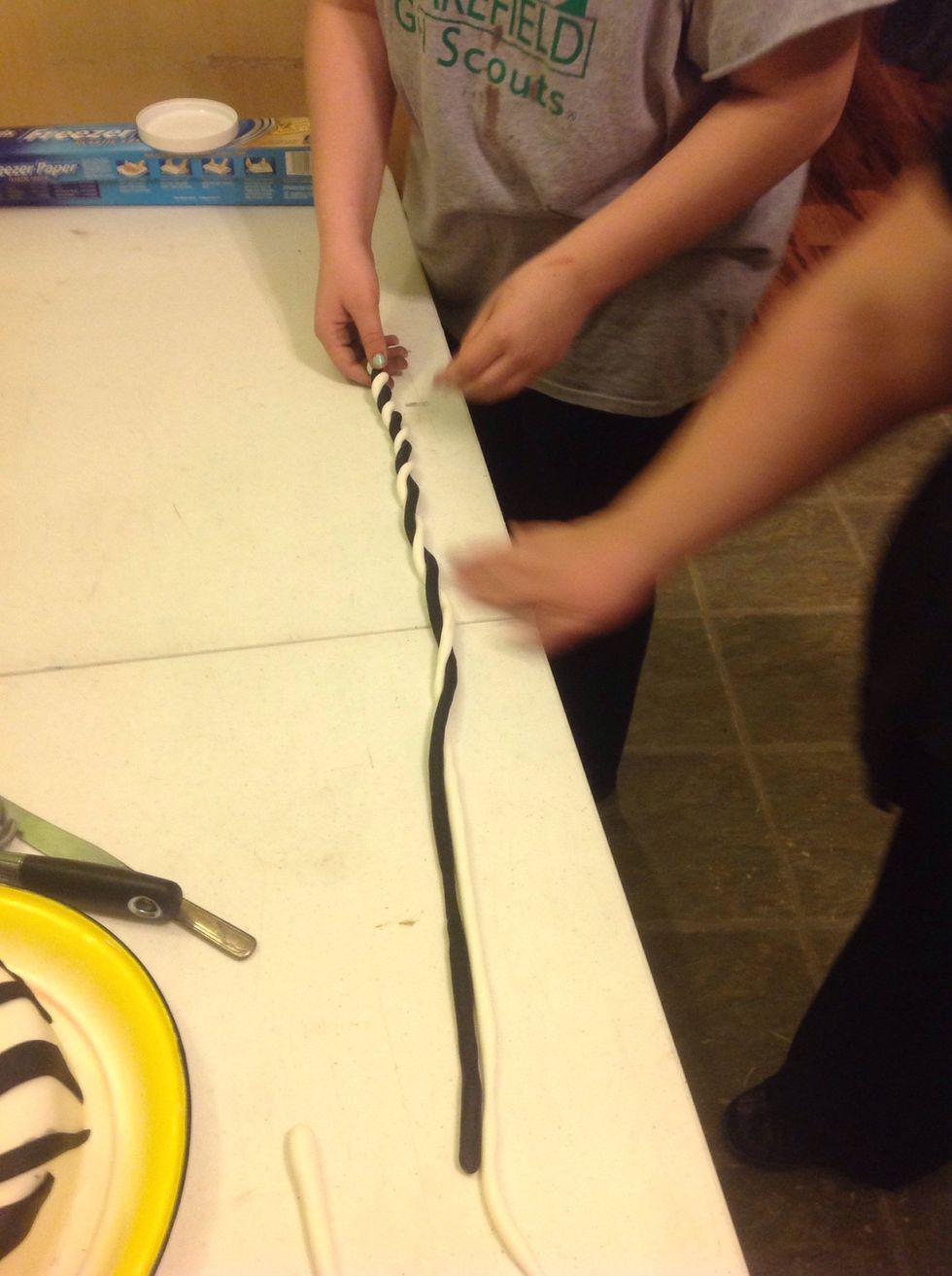 Begin twisting the different color string together.