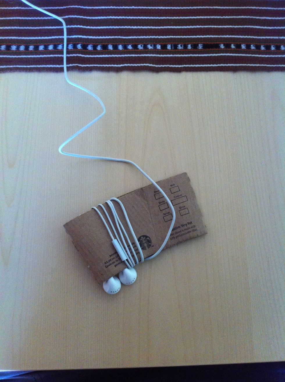 Begin winding the cords around the outside of the holder, the 'buds "clamped" in place. If you have a mic, play with how far the earbuds dangle out of the holder, so the winding accommodates the mic.