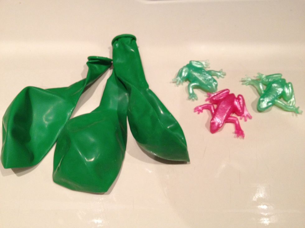 Begin with balloons and plastic toys, one set for each child attending the party. In this instance I have used stretchy rubber frogs. Place/squish the toy into the deflated balloon.
