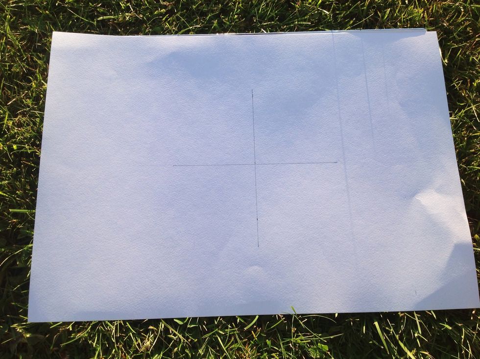 Begin with drawing a cross in the middle of the paper, use a ruler to make the lines straight and to measure the cross correctly. Each line is 6 centimetres from the middle.