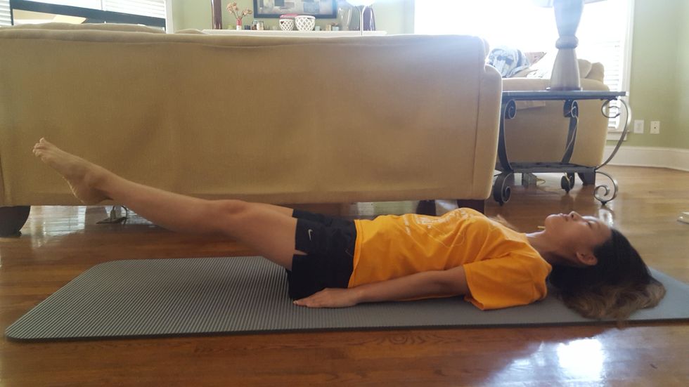 Begin with flutter kicks. Start in this position. Try your best to not let your feet hit the ground as this will keep your abdominal muscles engaged throughout the entire exercise.