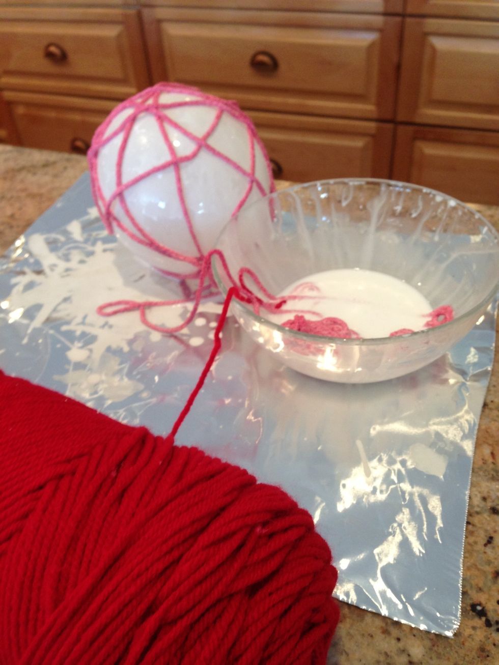 Begin wrapping wet yarn around balloon