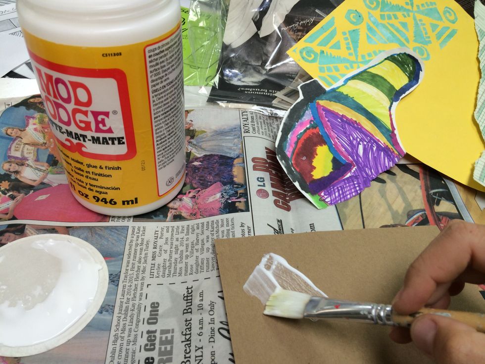 Begin your collage by applying a thin layer of Mod-Podge to the cardboard surface with a paint brush.