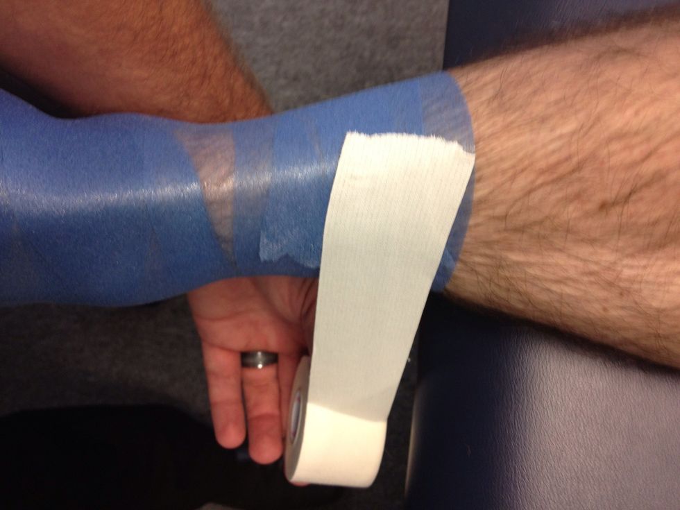 Begin your first top anchor just below the calf muscle. Angle the tape roll slightly toward the foot, with moderate tension complete the anchor by wrapping around the leg ending at the starting point.