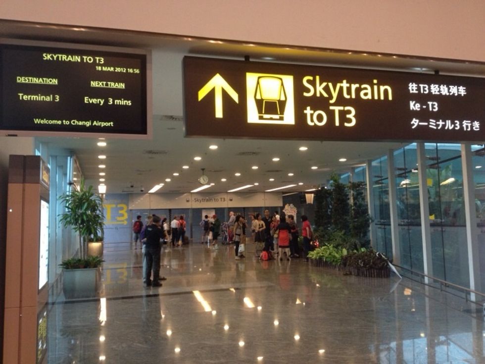 Behind the telephone boxes is the waiting area for the Sky Train. Sky Train are monorail trains connecting between terminals. You will now take a Sky Train to Terminal 3