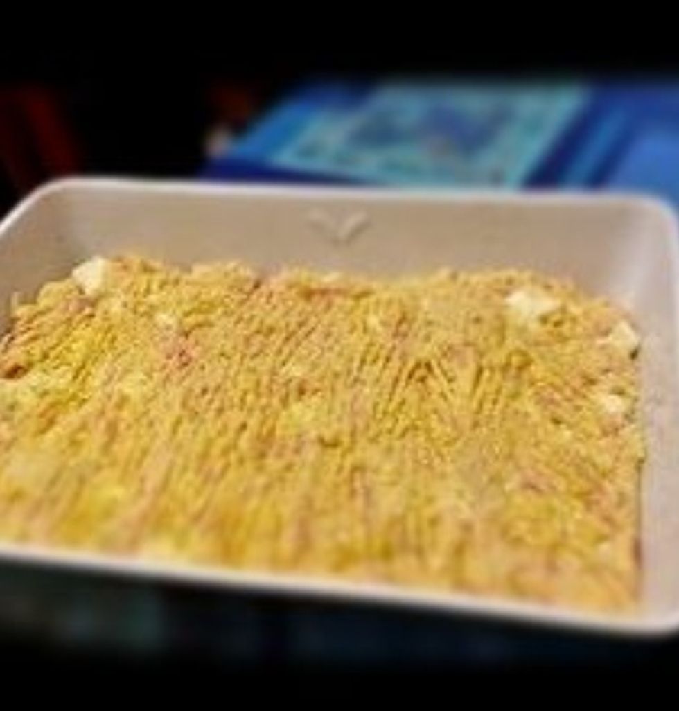 Beurrer et parsemer de chapelure un plat. Mettre le tout dans le plat et niveler avec une spatule. Parsemer la surface du g\u00e2teau avec le parmesan.