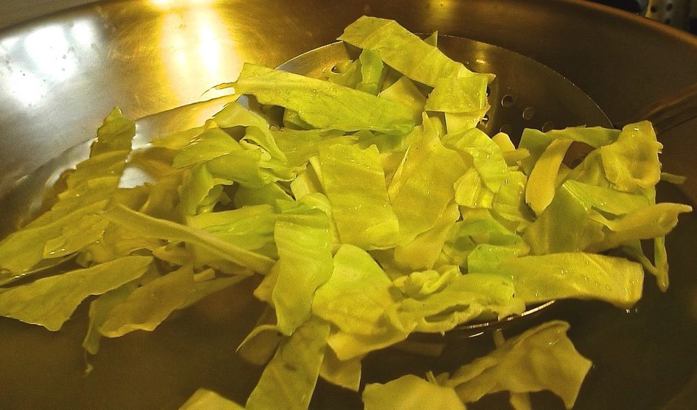 Blanch cabbage pieces in boiling water with half the vinegar added.