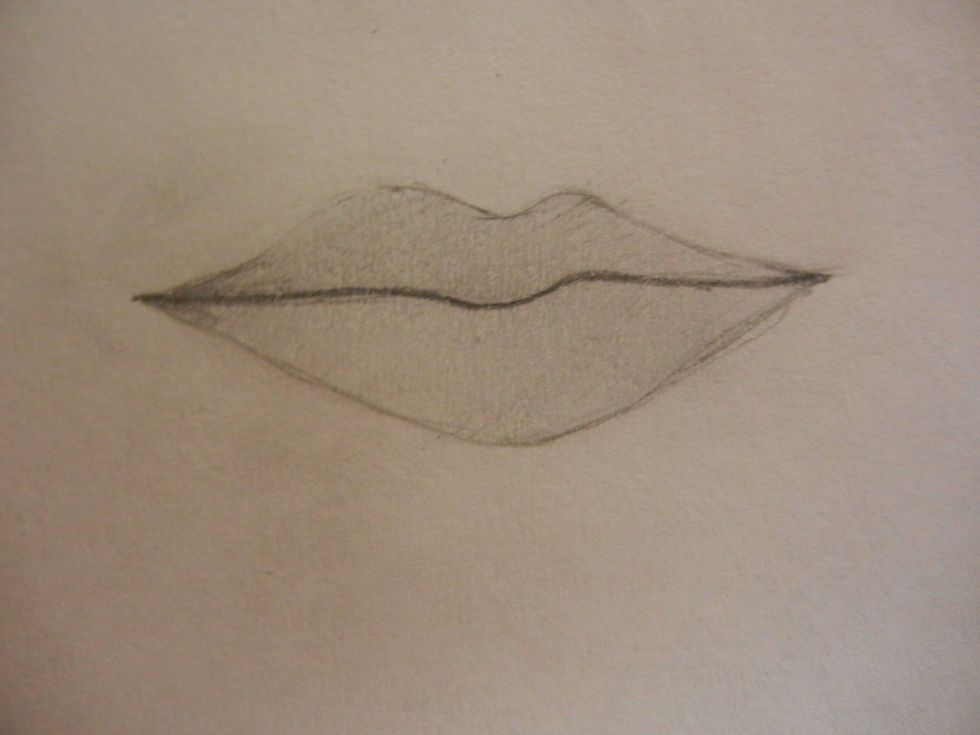 Blend the pencil smoothly , erasing the smudges outside of the lines. Go over the lines and make the line between the lips dark. Fill in the lip corners darker as well.
