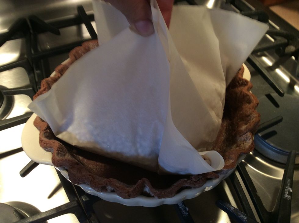 Blind bake (using the parchment paper and beans) for 30 minutes, carefully lift and remove the paper containing the beans and set aside. These can be used again later. Continue to bake for 10 minutes.