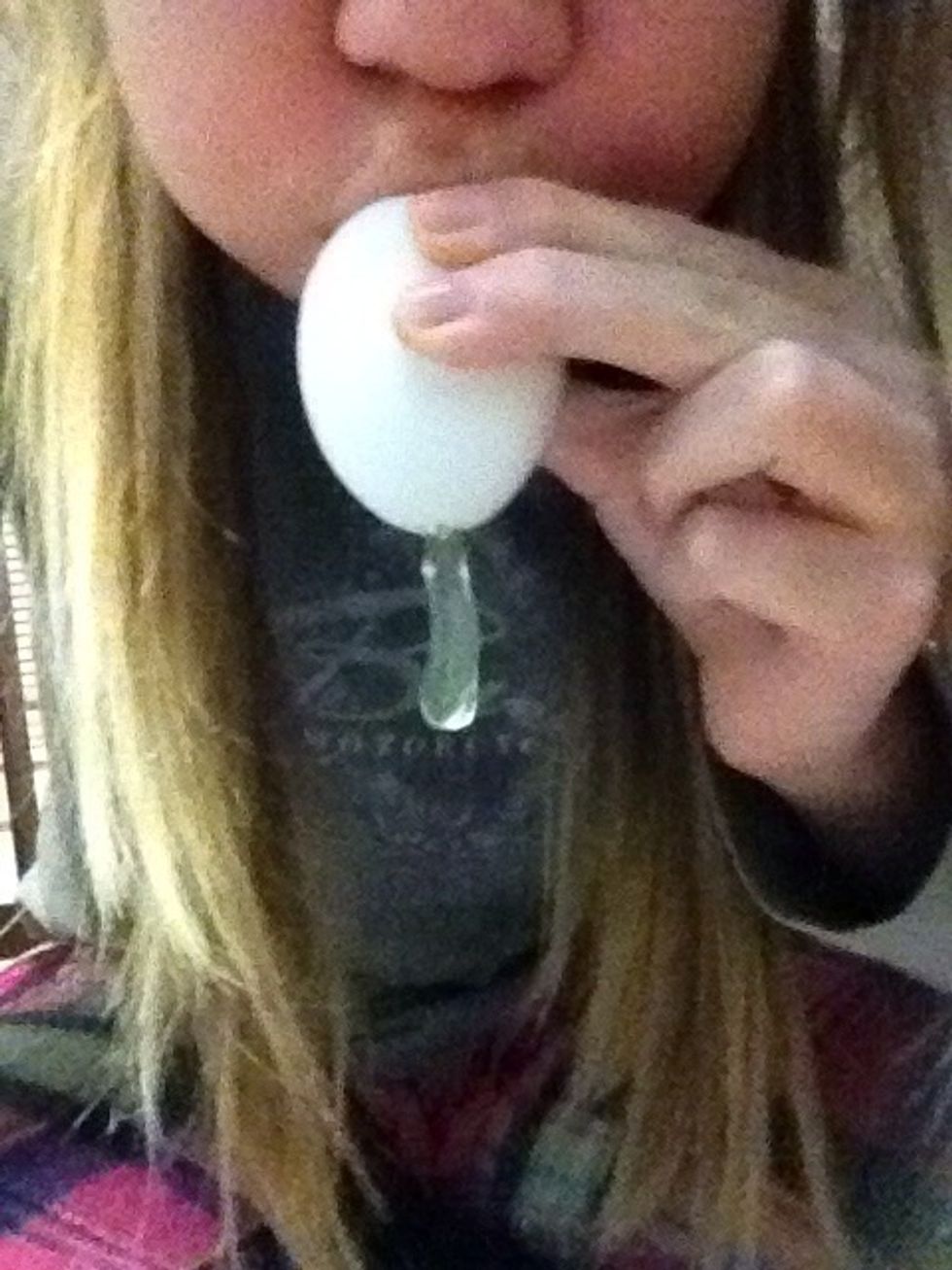 Blow into the small hole over a trash can. This step takes some work!