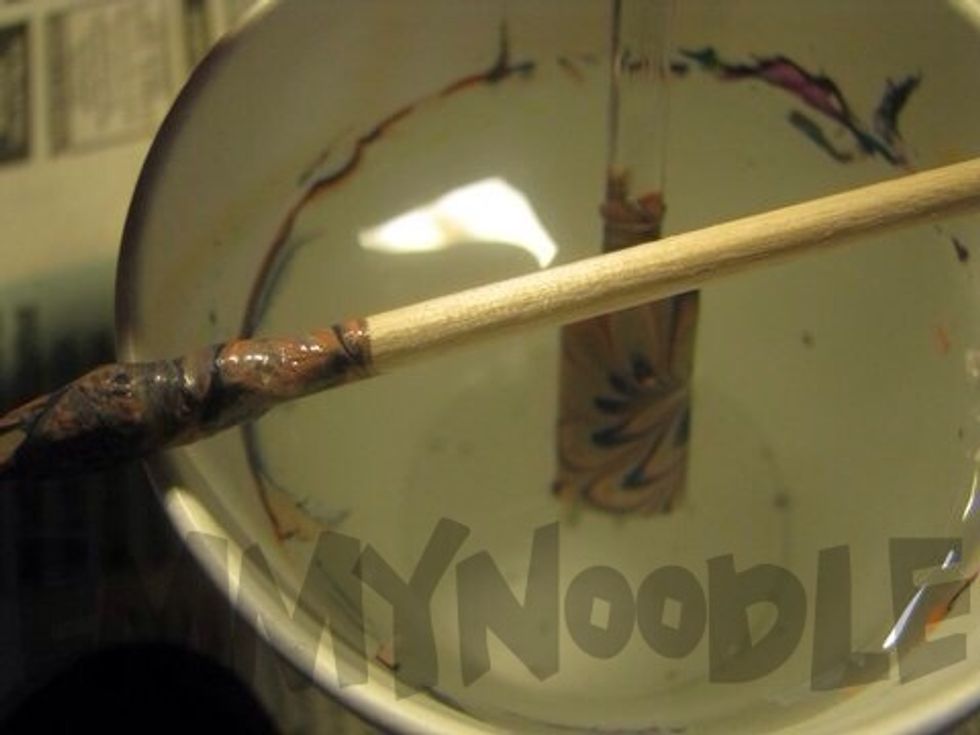 Blow on the water for 15 seconds before taking your orange stick and using a twirling motion to pick up all of the leftover polish on the surface of the water.