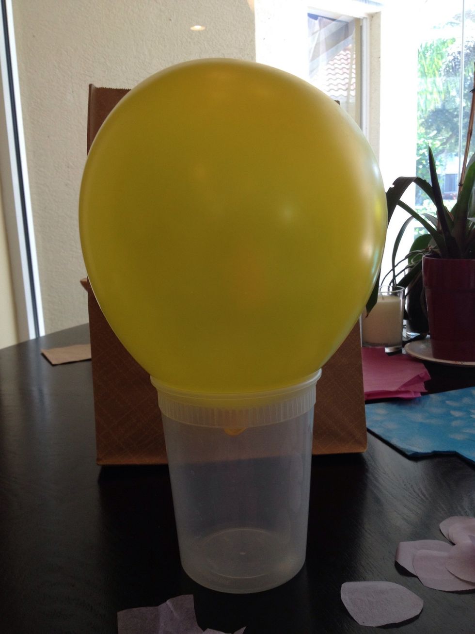 Blow up a balloon and put it on the wide-mouthed cup.