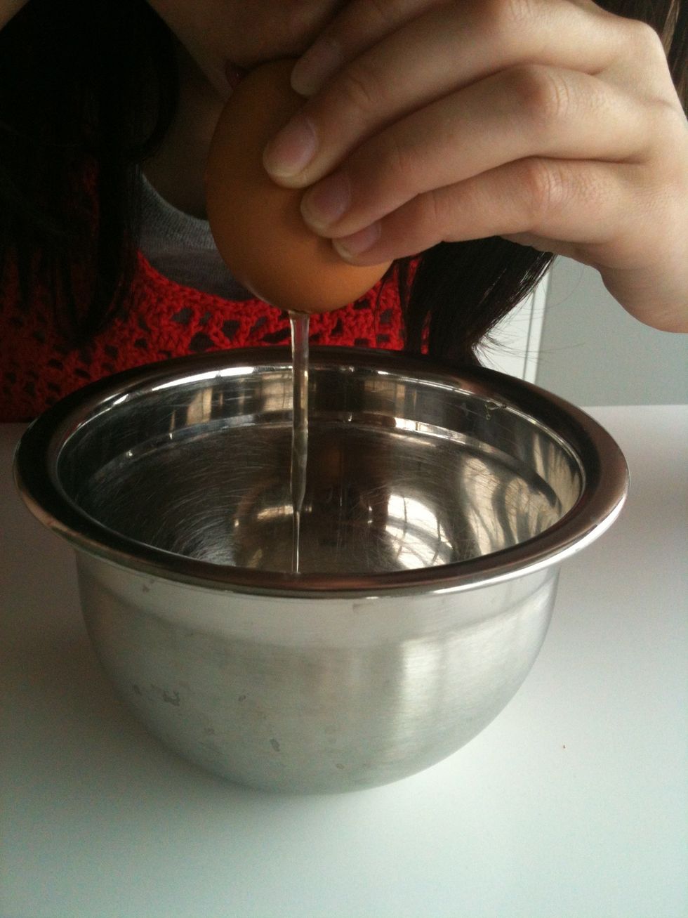 Blowing through the smaller hole, extract all the contents of the egg into a bowl.