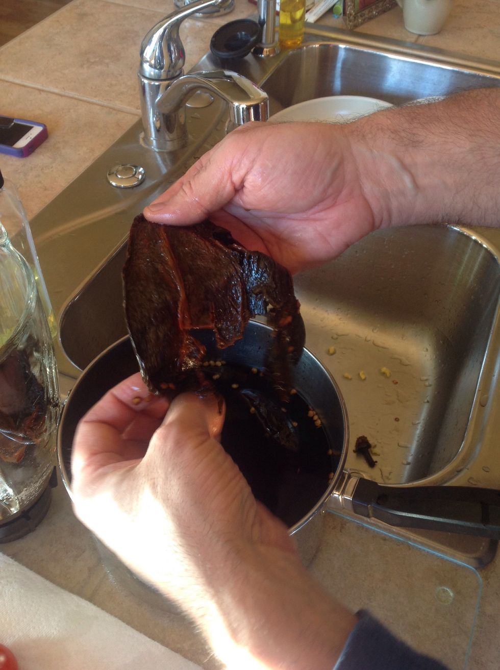 Boil dried peppers and cool. Reserve liquid. Split, strip, discard seeds .