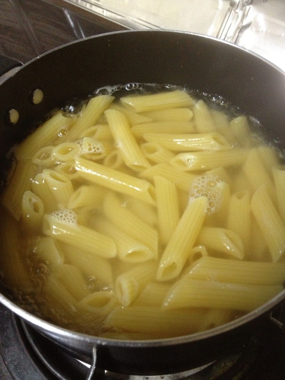 Boil penne pasta in hot water with added pinch of salt for 15 minutes (gradually stir so that the pasta won't stick together)
