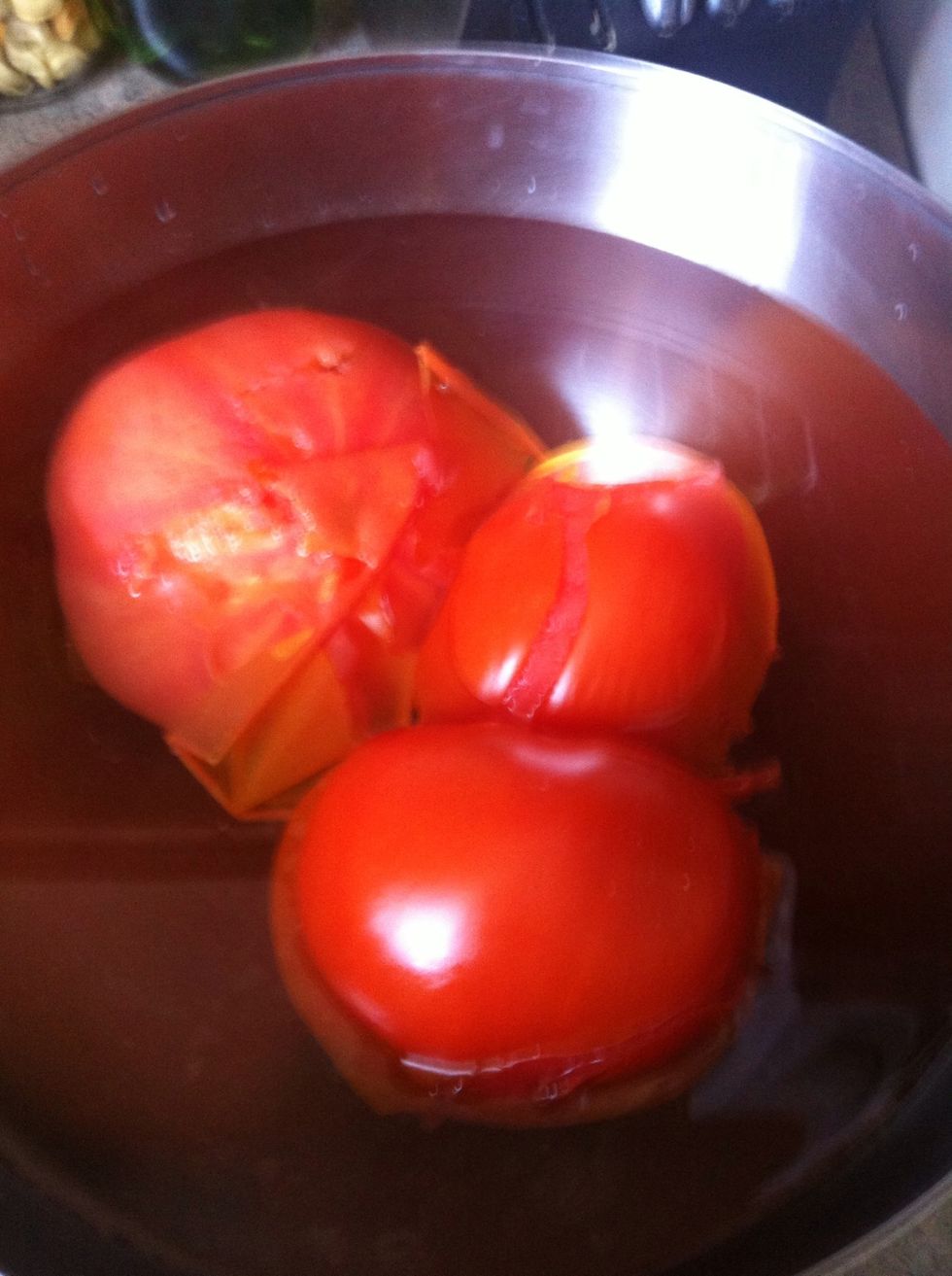 Boil the tomatoes until the skin starts peeling like so