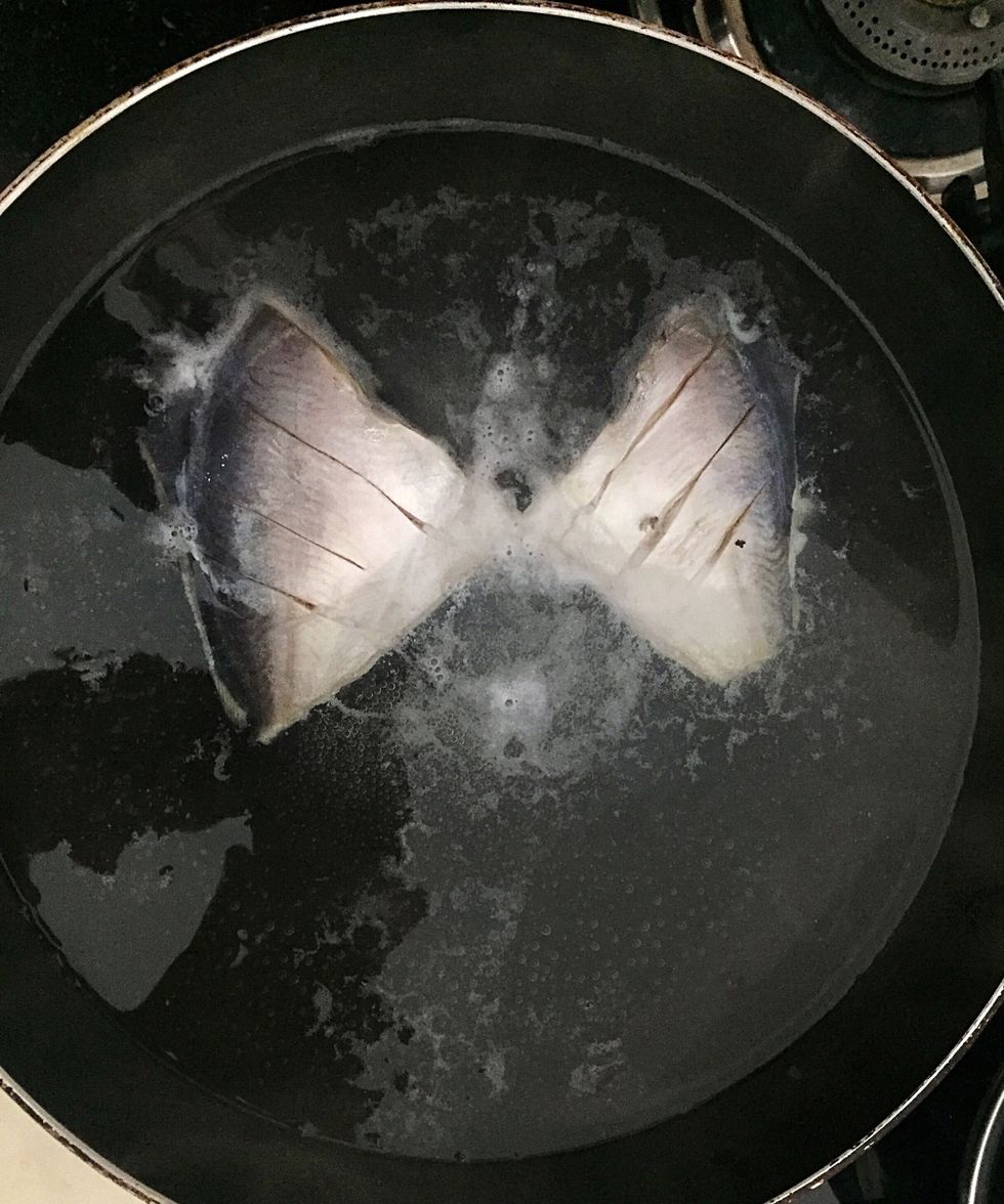 Boil water in a flat pan. Add one table spoon of chilly vinegar. Add fish and boil for 12 mins in low flame. Turn fish in between.