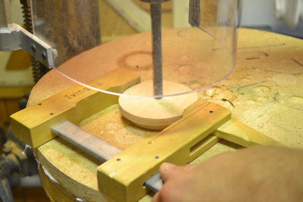 Borra h\u00e5l f\u00f6r knoppen (oftast 11mm). St\u00e4ll in stoppet p\u00e5 pelarborren s\u00e5 att den inte borrar igenom locket men tillr\u00e4ckligt djupt f\u00f6r knoppen. H\u00e5ll fast med en tving f\u00f6r s\u00e4kerheten.