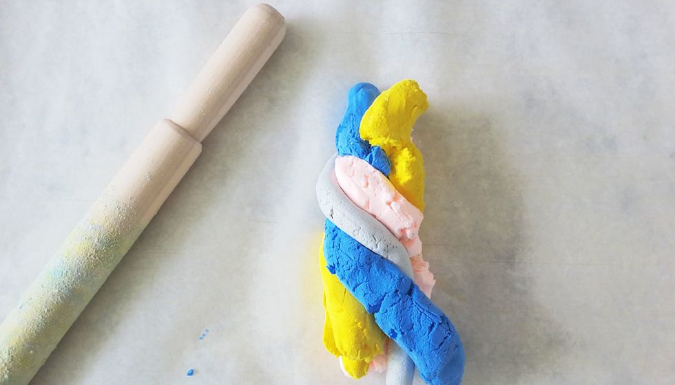 Break off a small chunk of each coloured clay and roll into long thin (snake-like) pieces. These can vary in length and width. Then, twine the long pieces together.