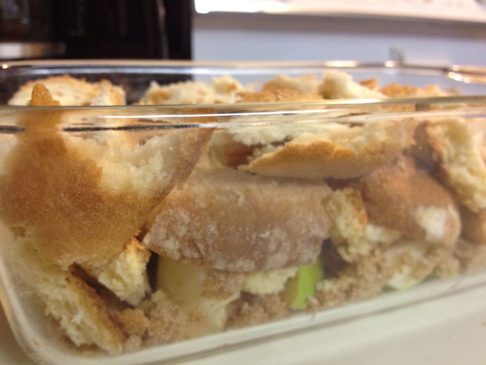 Break the bread slices into bite-size pieces and layer them on top of the apples. Try to fill gaps between apples so the juices are absorbed when baked.