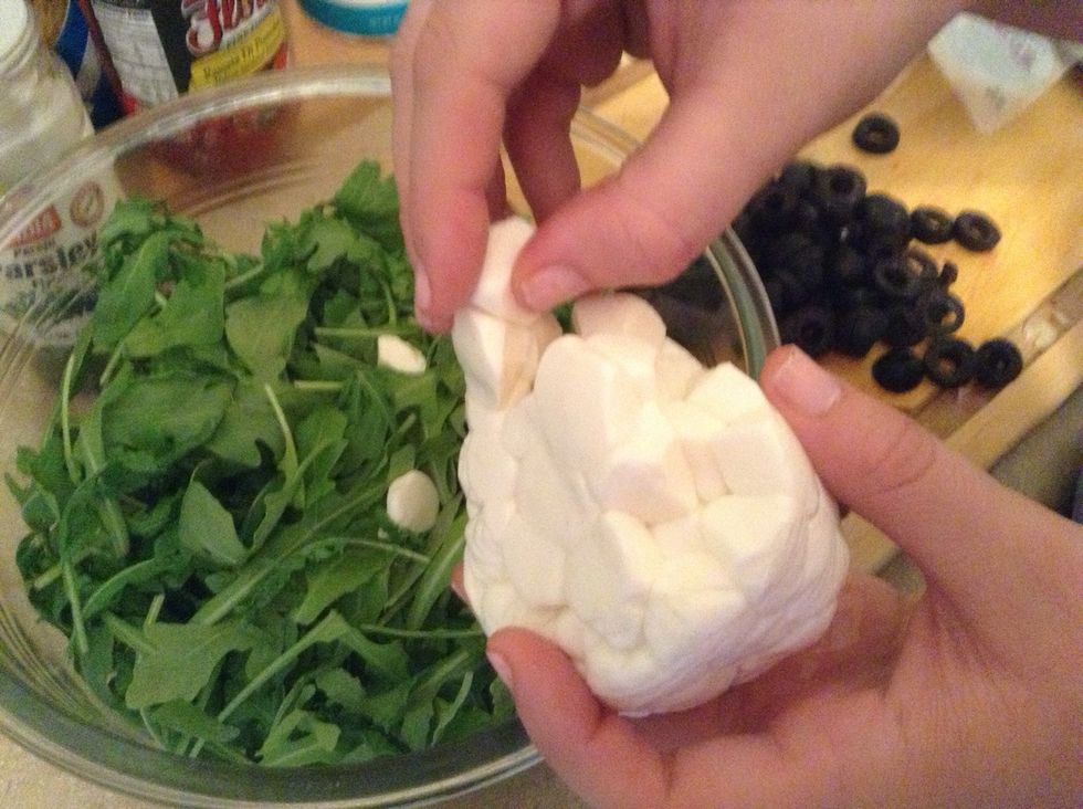 Break up pearls of mozzarella and add to arugula