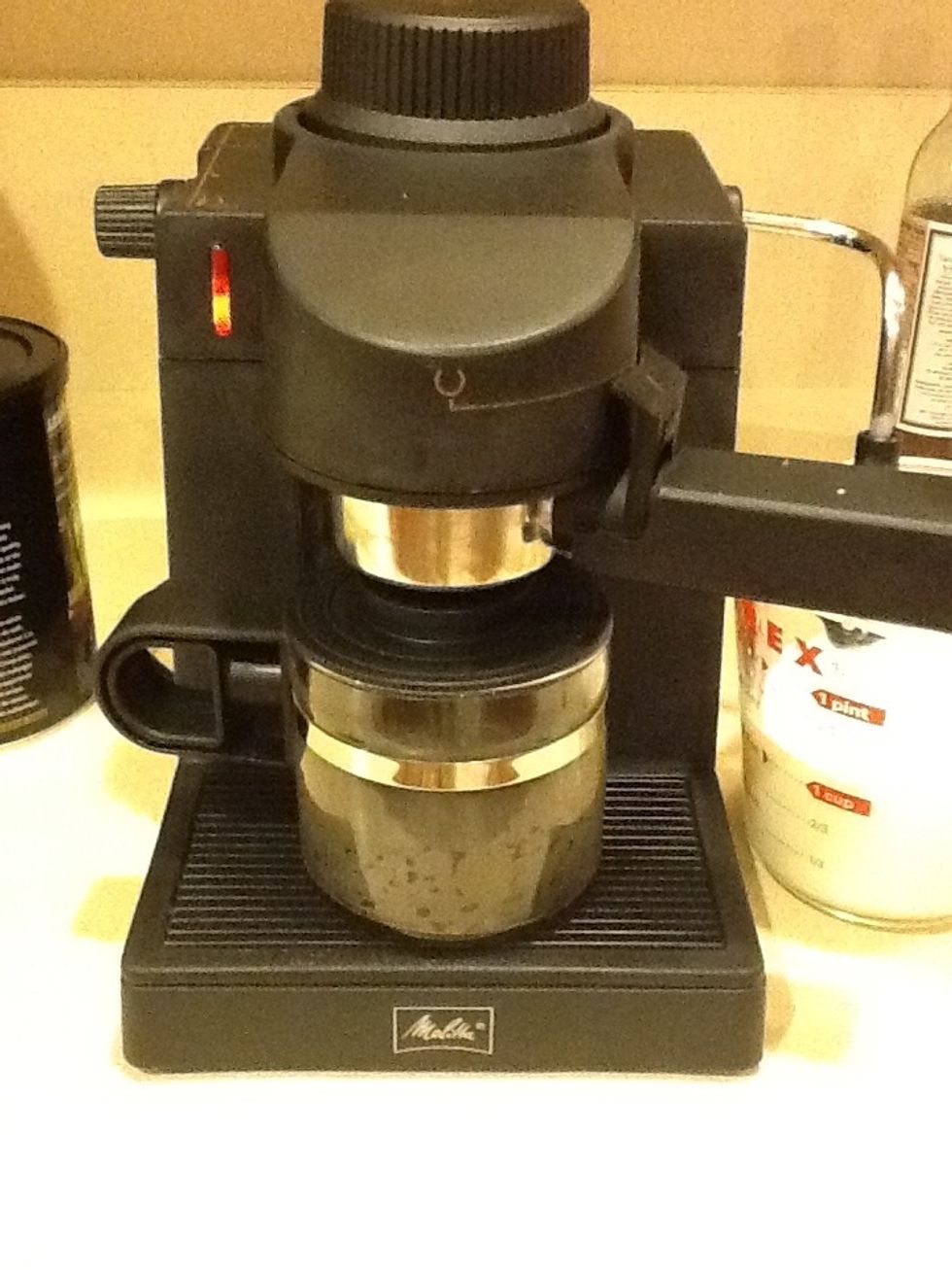 Brew espresso remove and pour into mug, top with steamed milk