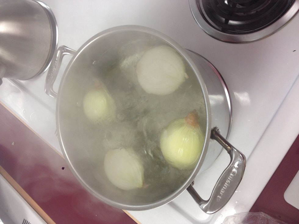 Bring 2 quarts of water to a boil, and drop onion halves in and blanch for 2 minutes