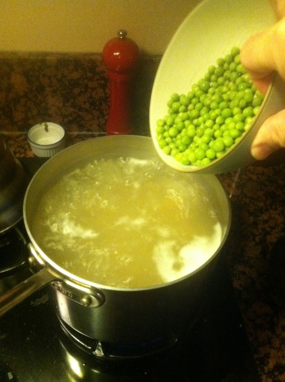 Bring a pot of salted water to the boil and add your pasta. About 2 minutes before it's done, throw the peas in with it to blanch them.