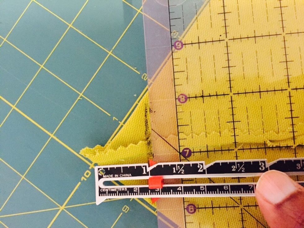 Bring corner into a triangle and measure about an inch. Mark with a fabric pencil and then sew the triangle down. Do this for both sides.