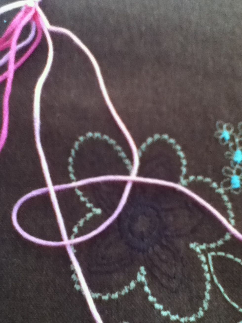 Bring rightmost strand around the next strand and back over itself. Bring knot to top of strands. This is a backwards/reverse knot. Repeat using same two threads.