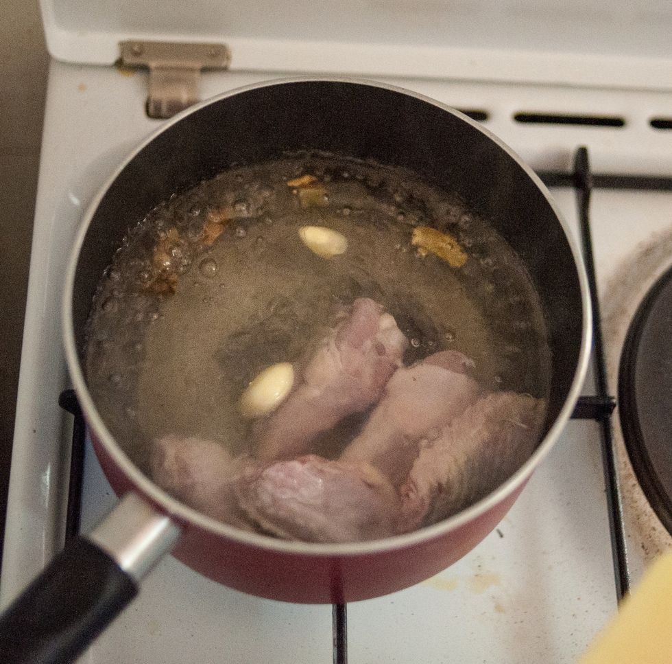 Bring some water to a boil then add the chicken pieces together with crushed whole ginger and garlic. Add some salt as well and cook for about 5 minutes