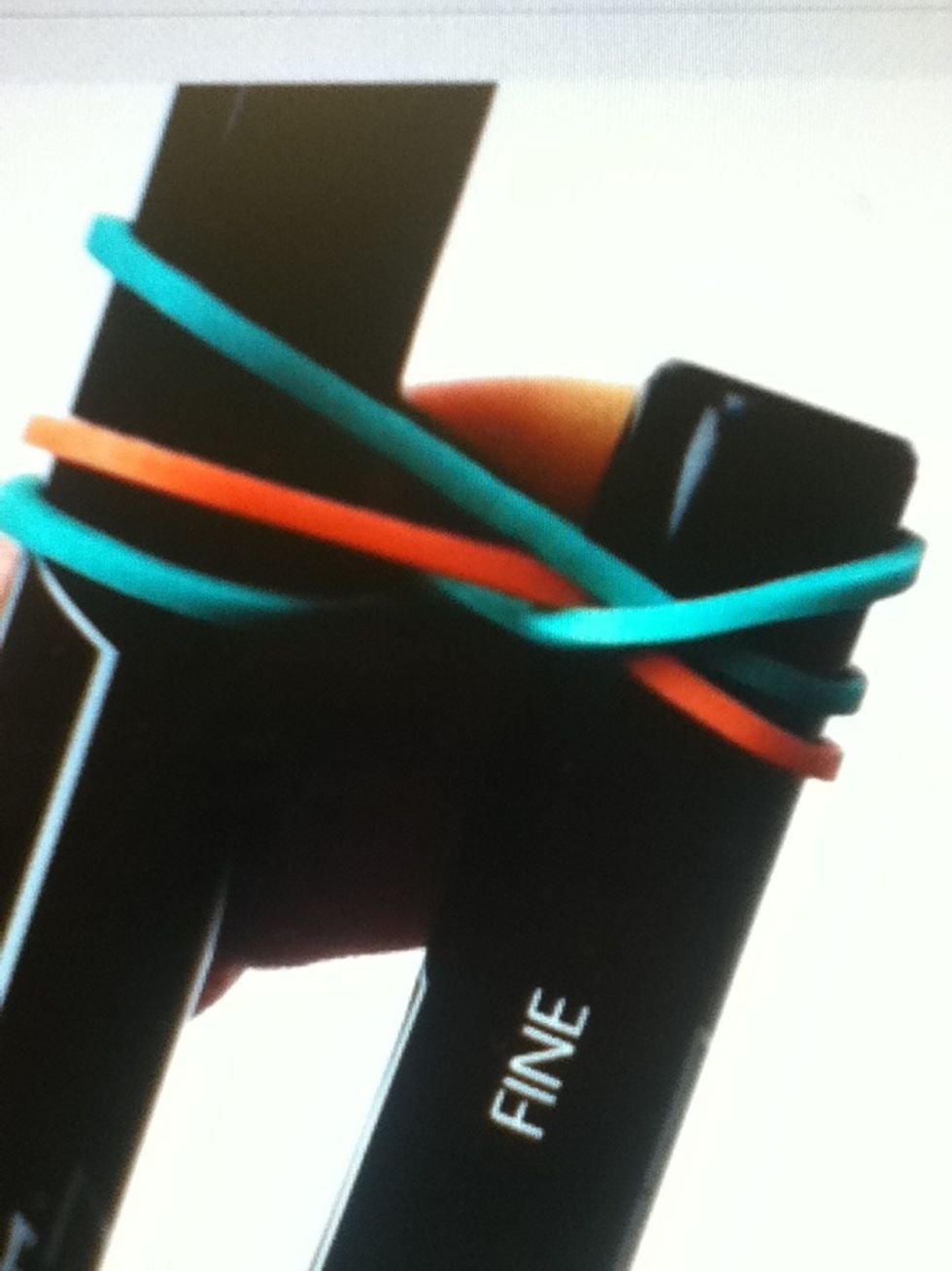 Bring the bottom right elastic of the top of the pen on the right.